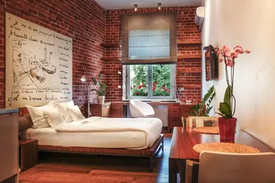 a room with a bed and a brick wall at Apartamenty Straszewskiego in Kraków