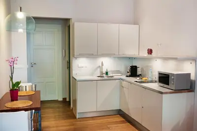 a kitchen with white cabinets and a microwave at Apartamenty Straszewskiego in Kraków