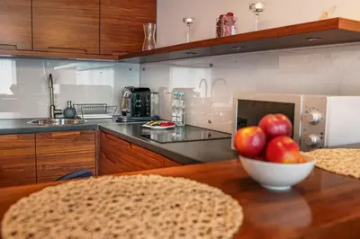 a kitchen with a bowl of apples on a table at Apartamenty Straszewskiego in Kraków