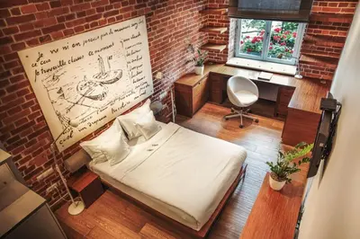 a bedroom with a bed and a brick wall at Apartamenty Straszewskiego in Kraków