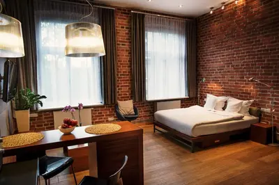 a bedroom with a bed and a brick wall at Apartamenty Straszewskiego in Kraków