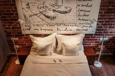 a bed with a wall with a sign above it at Apartamenty Straszewskiego in Kraków