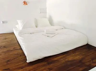 two white beds in a room with a wooden floor at Przestrzenny apartament w centrum Krakowa. in Kraków