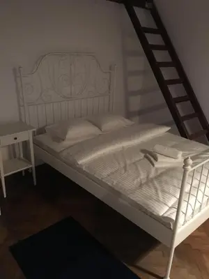 a white bed in a room with a ladder at Przestrzenny apartament w centrum Krakowa. in Kraków