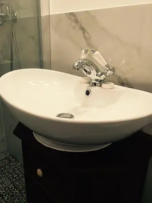 a white sink in a bathroom with a shower at Przestrzenny apartament w centrum Krakowa. in Kraków