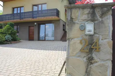 a house with a stone wall with a number on it at Apartament Kapi in Kalwaria Zebrzydowska