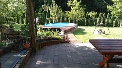 a backyard with a swimming pool and a table at Apartament Kapi in Kalwaria Zebrzydowska