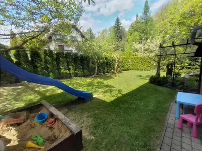 a yard with a playground with a blue slide at Apartament Kapi in Kalwaria Zebrzydowska
