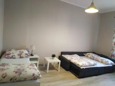 a room with two beds and a couch and a table at Apartament Romantic in Oświęcim