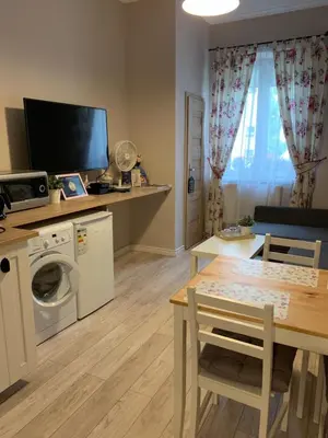 a small living room with a table and a dining room at Apartament Romantic in Oświęcim