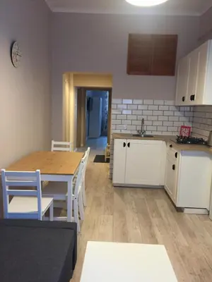 a kitchen and living room with a table and a table and chairs at Apartament Romantic in Oświęcim