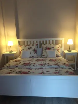 a bedroom with a white bed with two lamps at Apartament Romantic in Oświęcim
