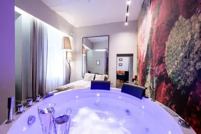a large bath tub in a room with a bedroom at Arts Apartments - Kraków Old Town in Kraków