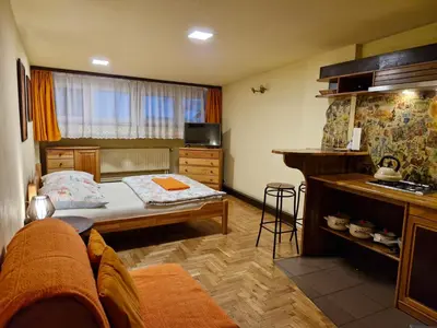a small room with a bed and a kitchen at Indalo Rooms in Kraków