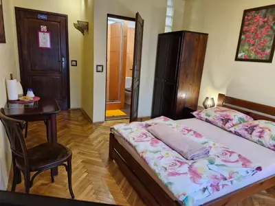 a bedroom with a bed and a table and a chair at Indalo Rooms in Kraków
