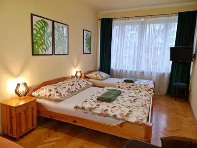 a bedroom with two beds and a window at Indalo Rooms in Kraków
