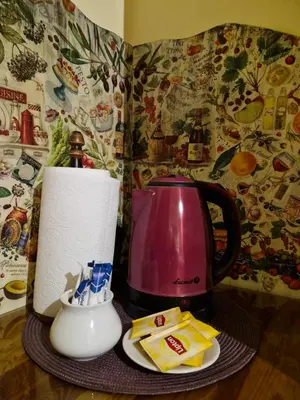a table with a pink tea pot and a paper towel at Indalo Rooms in Kraków