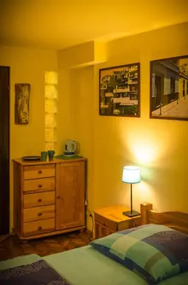 a bedroom with a bed and a dresser and a lamp at Indalo Rooms in Kraków