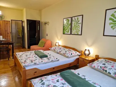 a room with two beds and a chair in it at Indalo Rooms in Kraków