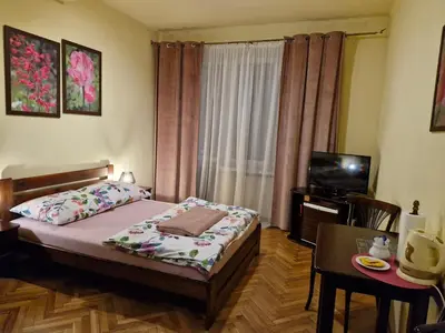 a small bedroom with a bed and a television at Indalo Rooms in Kraków