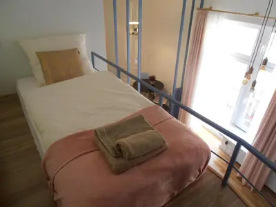 a bed with a pillow on it in a bedroom at Apartamenty Rudi in Kraków