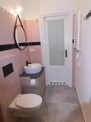 a pink bathroom with a toilet and a sink at Apartamenty Rudi in Kraków