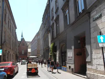 a group of people walking down a city street at Apartamenty Rudi in Kraków