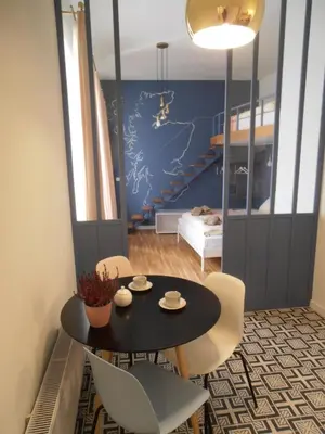 a room with a table and chairs and a staircase at Apartamenty Rudi in Kraków
