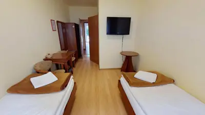 a room with two beds and a tv on the wall at Noclegi Czarna Perła in Kraków