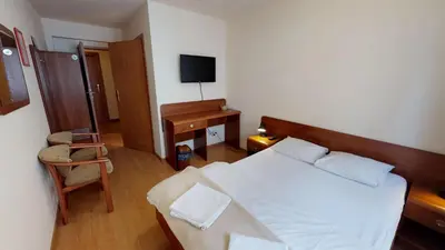 a bedroom with a bed and a desk with a television at Noclegi Czarna Perła in Kraków