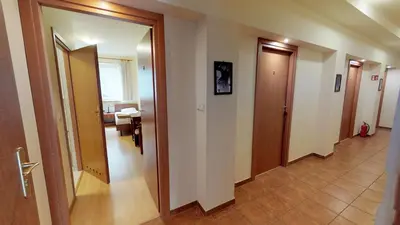 a hallway with two doors and a room with a table at Noclegi Czarna Perła in Kraków