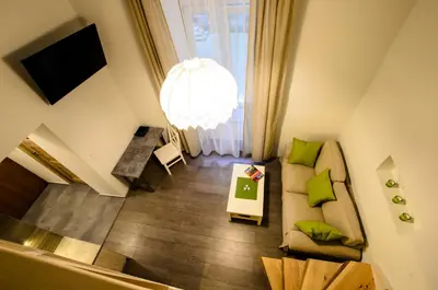a living room with a couch and a chandelier at Apartamenty Winnicy Kresy II in Kraków