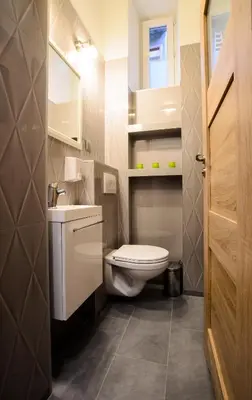 a bathroom with a white toilet and a sink at Apartamenty Winnicy Kresy II in Kraków