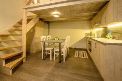 a kitchen with a table and chairs in a room at Apartamenty Winnicy Kresy II in Kraków