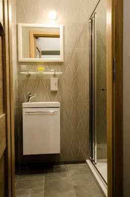 a bathroom with a toilet and a sink and a mirror at Apartamenty Winnicy Kresy II in Kraków