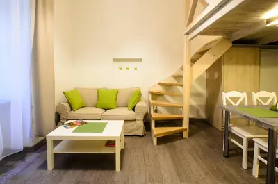a living room with a couch and a staircase at Apartamenty Winnicy Kresy II in Kraków