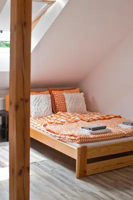 a bed with a wooden frame in a room at Hostel 33 in Trzebinia