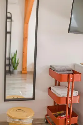 a mirror on a wall next to a shelf with towels at Hostel 33 in Trzebinia