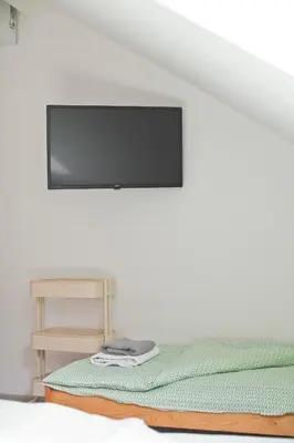 a flat screen tv hanging on a wall above a bed at Hostel 33 in Trzebinia