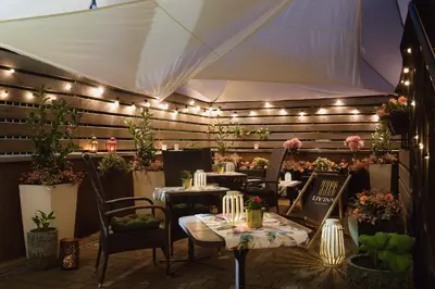 a patio with tables and chairs and lights at Liv'Inn Aparthotel in Kraków