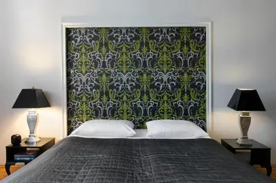 a bedroom with a bed with a green and black wallpaper at Liv'Inn Aparthotel in Kraków