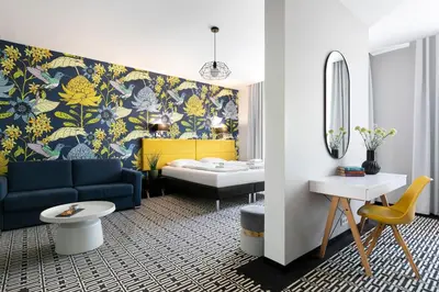 a living room with a blue couch and a bedroom at Liv'Inn Aparthotel in Kraków