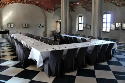 a row of tables in a room with black chairs at Dom Gości Opactwa Benedyktynów in Tyniec