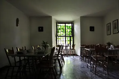 a dining room with tables and chairs and a window at Dom Gości Opactwa Benedyktynów in Tyniec