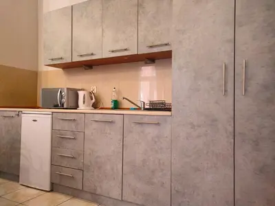 a kitchen with stainless steel cabinets and a sink at Apartament Izaaka in Kraków
