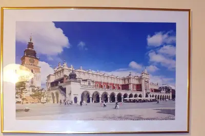a framed picture of a building with a clock tower at Apartament Izaaka in Kraków