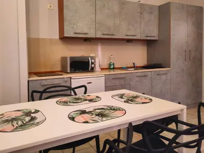 a kitchen with two tables and chairs in it at Apartament Izaaka in Kraków