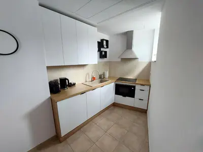 a small kitchen with white cabinets and a sink at NOOK NOOK Apartments Kazimierza Wielkiego 104 in Kraków
