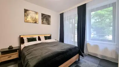a bedroom with a bed and a large window at NOOK NOOK Apartments Kazimierza Wielkiego 104 in Kraków
