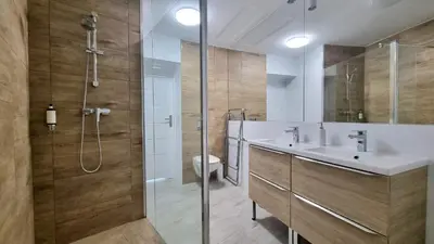 a bathroom with a shower and a sink and a toilet at NOOK NOOK Apartments Kazimierza Wielkiego 104 in Kraków
